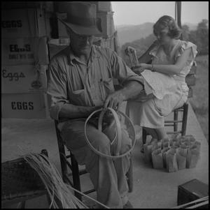 [Photograph of a man and a girl working on the porch]