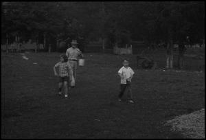 [Photograph of a family walking through a clearing]