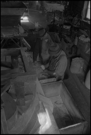 [Photograph of two men packing sawdust, 1]