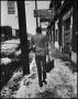 Photograph: [Man walking down a snowy sidewalk]