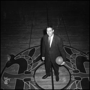 [Coach Charles Johnson standing with a basketball]