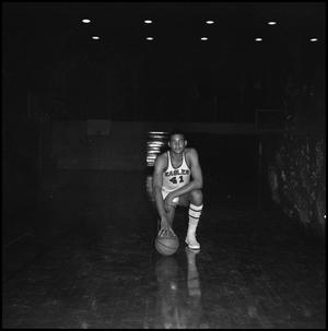 [Basketball player posing with a basketball]
