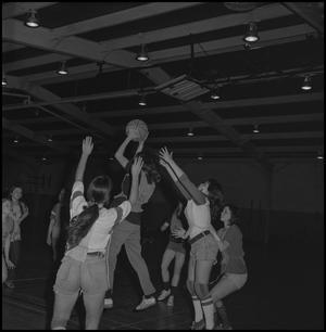 [Basketball players reaching for ball]