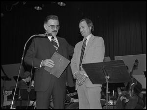 [Breeden presenting a plaque to Myers]