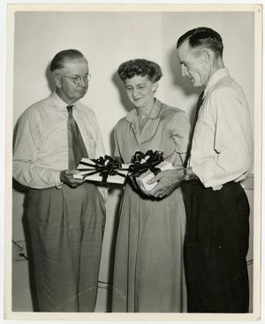 [Fowler, Babb, and Hannah stand with gifts]