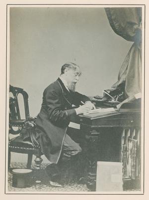 [Photograph of Charles Dickens writing at desk]