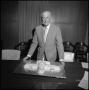 Photograph: [Board of Regents member with airplane cake]