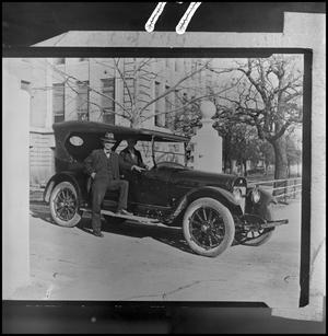 [President William Bruce standing next to car]