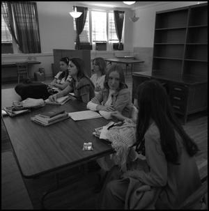 [Teresa Bond seated at table with other students, from side]