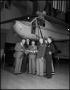 Photograph: [Five men standing with a model plane]
