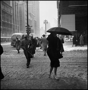 [People crossing the street in the snow]