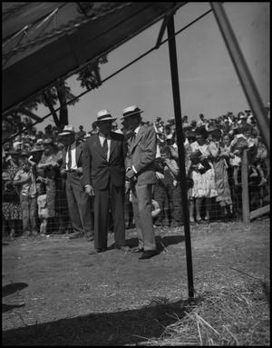 Primary view of object titled '[Two men standing in front of a crowd]'.