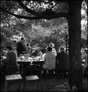 [Large family dining together outdoors]