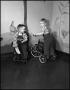 Photograph: [Two boys riding toys in a nursery]