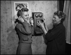 [Two women and a wall telephone]