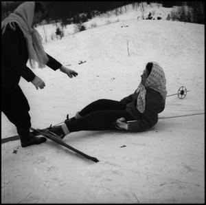 [Skier helping another stand after falling]