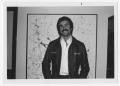 Photograph: [Bill Nelson smiling in front of art]