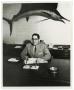 Photograph: [Frank Cuellar Sr. sitting on a desk]