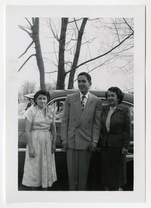 [Frank Cuellar Jr. and two women in front of car]