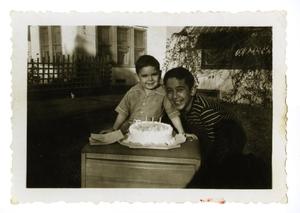 Primary view of object titled '[Bob Cuellar and Frank Cuellar Jr. with cake]'.