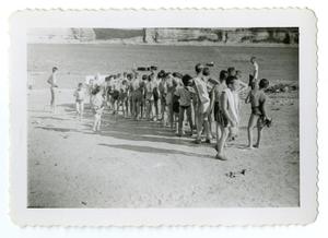 [Bob Cuellar and other boys in forming a line in front of a lake]