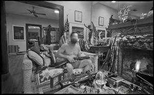 [Man sitting in his living room with a gun]