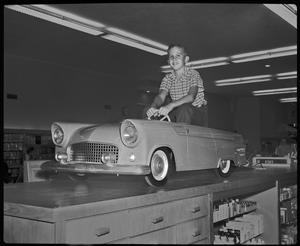 [Boy in a car in Monnig's department store]