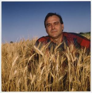 [Dr. Miguel Acevedo sitting in wheat field]