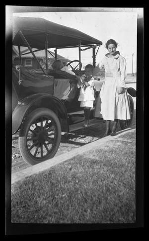 [Irene Williams posing next to a Model T]