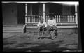 Photograph: [Charles and John Williams sitting in front of a house]