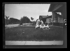 [Irene Williams sitting in her front yard with her sons John and Byrd III]