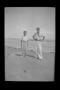 Photograph: [Charles and John Williams standing on a beach]