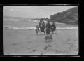 Photograph: [Charles, Irene, Byrd, and John Williams walking on a beach]