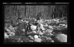 [The Williams family sitting next to a stream]
