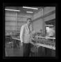 Photograph: [A Bell employee standing at a work table]