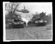Photograph: [The Bell H-40 flying over tanks]