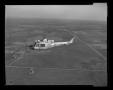Primary view of [XH-40 number 3 in first flight over Hurst plant]