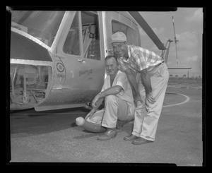 [Two Bell employees pose near an XH-40]
