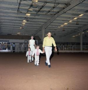 [Parents and Two Children In a Roping Arena]
