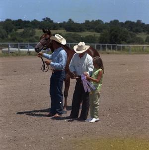 [Two Men and a Girl with a Young Chestnut Horse]