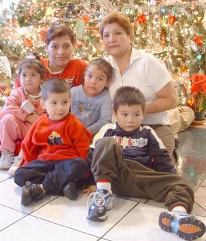 [Family poses next to the Christmas tree]