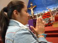 Primary view of [Woman prays in a church at Christmas time]