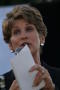 Photograph: [Close-up of Laura Miller holding white paper and microphone]