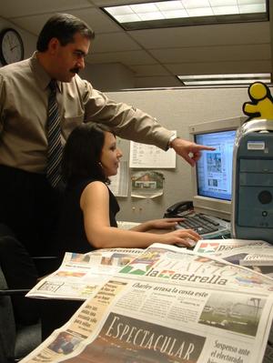 [Juan A. Ramos and woman at computer with "La Estrella" in foreground]