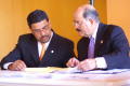 Photograph: [Hector Flores and another man reviewing documents at a table]