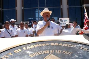 [Hector Flores speaking behind seal for City of Farmers Branch]