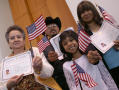 Thumbnail image of item number 1 in: '[New United States citizens hold up their certifactes and U. S. flags]'.