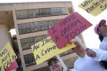 Photograph: [Protesters carry signs in front of Dallas City Hall]