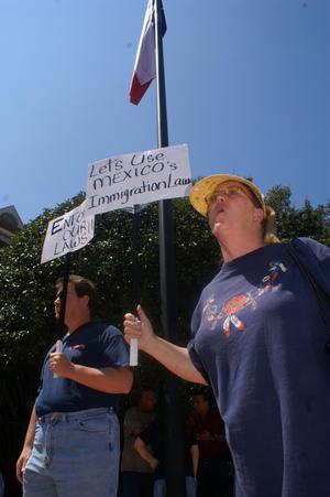 Primary view of object titled '[Two anti-immigration protesters with signs]'.