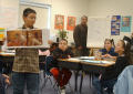 Primary view of [Student holds up a book in class to show everyone the pictures]